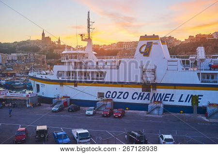Ghajnsielem, Malta - June 15, 2018: The Last Rays Of Fiery Sunset Over The Mgarr Harbour With A View