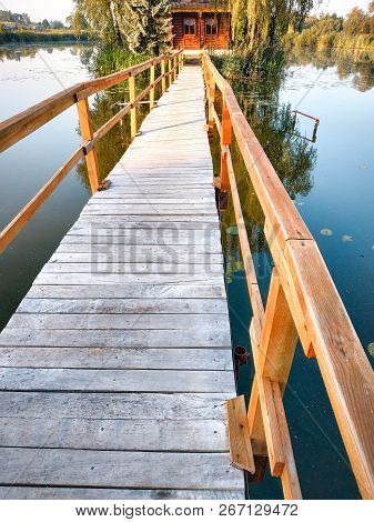 Small House One The Island. Landscape With Bridge To The House On Lake.