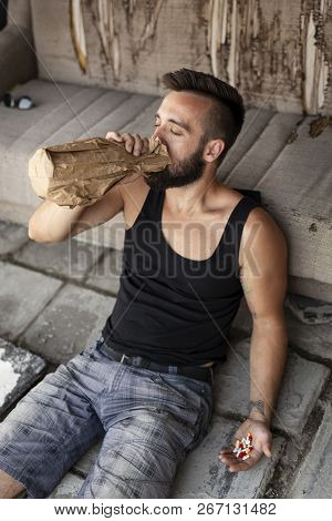 Man Lying On The Floor Drinkink Pills With Alcohol And Comitting A Suicide Attampt
