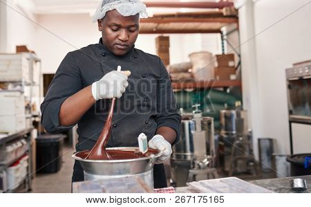 Worker Using A Bain Marie To Mix Melting Chocolate
