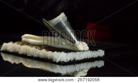 Close-up View Of Process Of Preparing Roll Sushi. Chef In Gloves Imposes From Pastry Bag Of Cream Fi