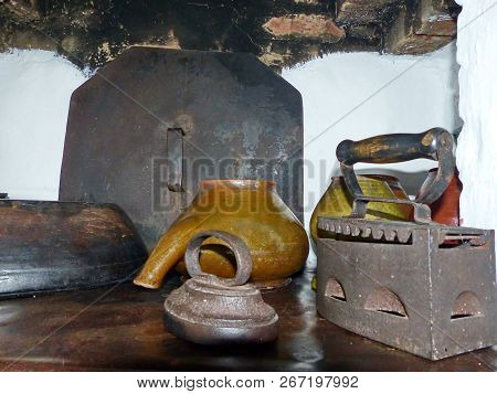 Rustic Cuisine. Iron And Kitchen Utensils On The Russian Oven. Peasant Izba. Closeup. Retro. Selecti