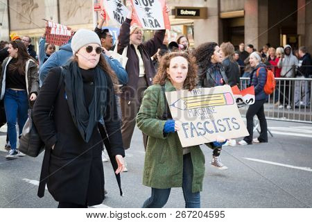 March For Our Lives: A woman holds a sign of a pencil and Woody Guthrie phrase This Machine Kills Fascists,  during the march to end gun violence on 6th Ave, NEW YORK MAR 24 2018.