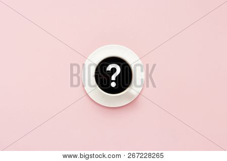 White Cup On A Saucer, Black Coffee, Pink Background. Question Mark. Flat Lay, Top View