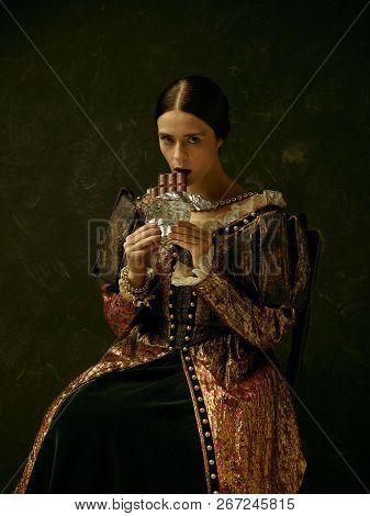Portrait Of A Girl Wearing A Princess Or Countess Dress Over Dark Studio. Portrait With Sweet Chocol