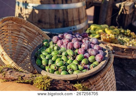 Kiwis And Plums In The Wooden Bowl