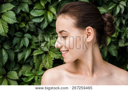 Smiling Young Woman With Green Leaves At Background