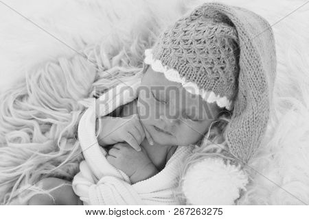 A Naked Newborn Baby Sleeps In A Christmas Hat.