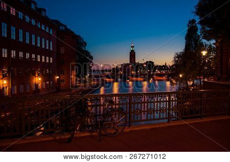 Bike, Bicycle Near Bridge Railing And Stockholm City Hall (stadshuset) Tower Building, Venue Of Nobe