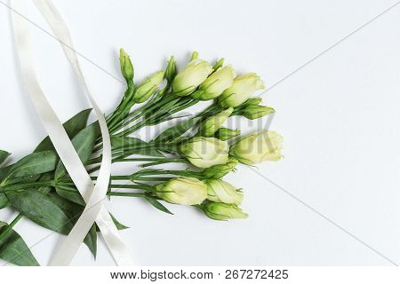 White Eustoma Fresh Flowers On Light White Background With Copy Space. Floral Greeting Card With Ros