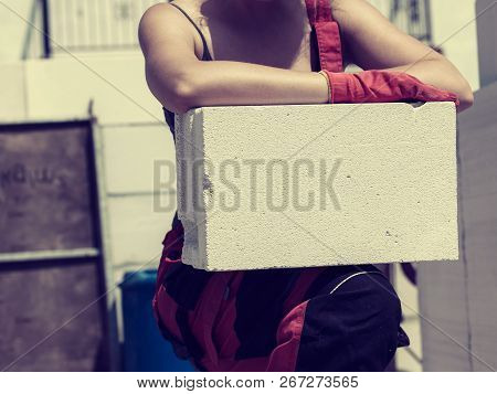 Unrecognizable Woman Working On Construction Site, Building House, Installing Gray Airbricks. Indust