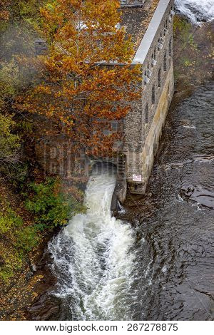 Pedestrian Suspension Bridge Over Triphammer Falls, Ithaca, New York. Waterfall In The Middle Of Cor
