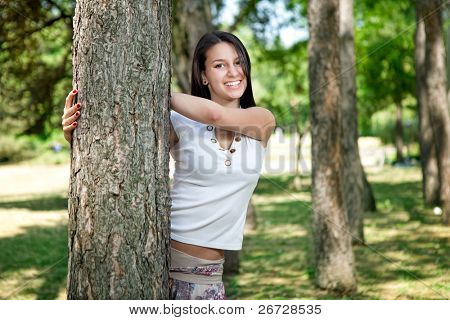 beautiful young woman in park playing peekaboo