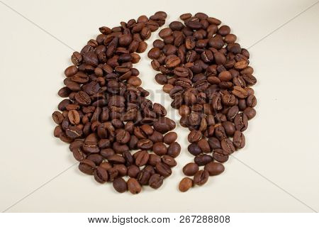 Roasted Brown Coffee Beans Laid Forming A Shape Of A Big Coffee Bean.