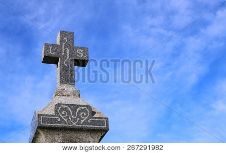 Close Up Of Cross On Top Of Granite Tombstone With Ihs Engraved For Jesus With Concept Of Eternal Li