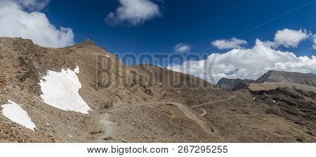 White Clouds Floating On Bright Blue Sky Over Majestic Veleta Mountain Ridge On Sunny Day In Sierra 