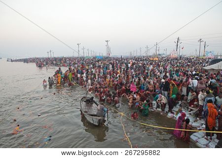ALLAHABAD, INDIA - FEBRUARY 12, 2013: Thousands of Hindu devotees come to confluence of the Ganges and Yamuna River for holy dip during the festival Kumbh Mela. The world's largest religious gathering