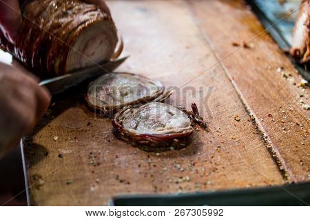 Man Is Preparing Kokorec (fried Sheep Bowel) With Knife On Wooden Surface.