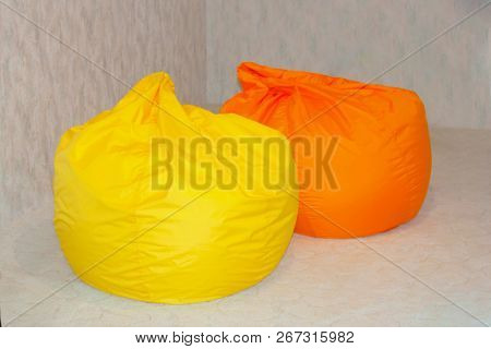 Frameless Chairs, Bags Of Various Colors Are On The Carpet. Bright Yellow And Orange Bean Bags In A 