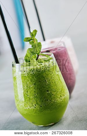Close-up portrait of nepali smoothy with passion fruit and peach juice. Bright cocktail with lemon and ice. Cooling drink concept. Isolated grey background