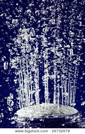 Doccia doccia mano con acqua ferma movimento gocce sul profondo blu