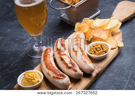 Grilled german sausages with mustard and fried potato chips