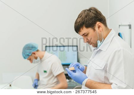 Doctor Used Microscope. Dentist Is Treating Patient In Modern Dental Office. Operation Is Carried Ou