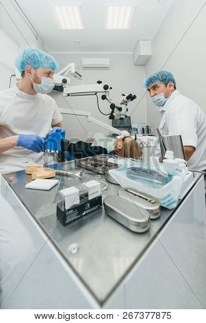 Doctor Used Microscope. Dentist Is Treating Patient In Modern Dental Office. Operation Is Carried Ou