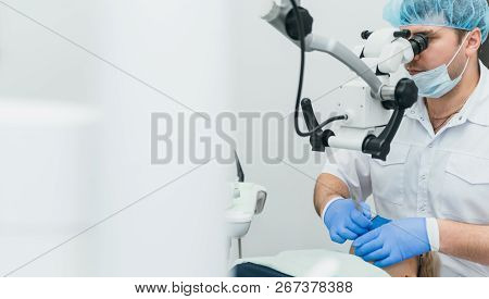 Doctor Used Microscope. Dentist Is Treating Patient In Modern Dental Office. Operation Is Carried Ou