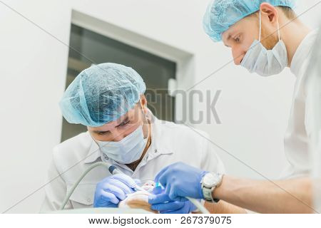 Doctor Used Microscope. Dentist Is Treating Patient In Modern Dental Office. Operation Is Carried Ou