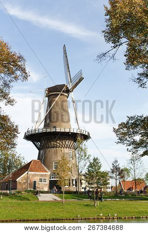 Molen De Valk Windmill At Leiden, Netherlands. Sunny Day And Sky With Clouds.
