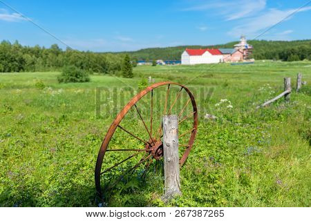 Old Rusty Wheel Thrown Into The Field.