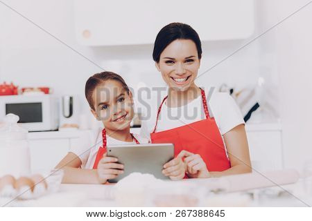 Motherhood For Young Daughter. Childhood With Mother And Kitchen. Woman And Girl. Love Girl And Moth