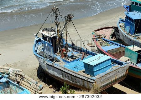 Old rustic fishing boats in Mancora, Peru on a sunny day