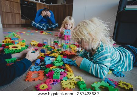 Kis Play At Home With Toys Scattered All Over And Tired Exhausted Father