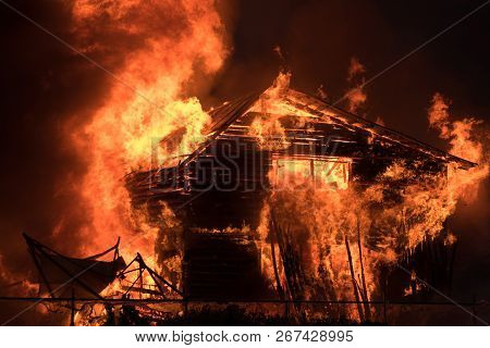 A Large Wooden One-story House Is Burning With A Bright Flame.