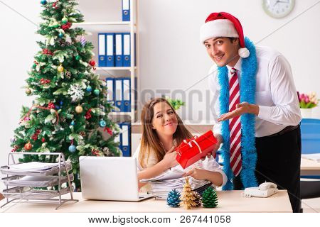 Colleagues exchaing christmas presents in office