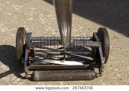 A Point Of View Look At A Reel Lawnmower After 90 Percent Of The Paint Was Removed