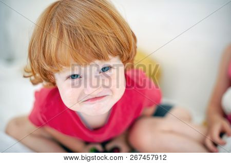Funny Red-haired Boy Contorts His Face Indoor