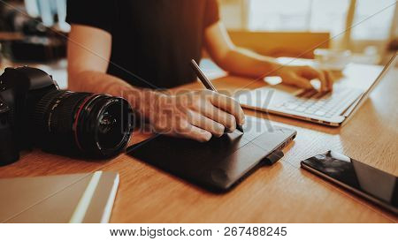Closeup Of Male Graphic Designer Hands Working. Guy Sitting At Table Retoch Photo Using Digital Tabl