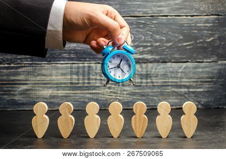 The Clock In The Hands Of A Businessman And Team. Overtime Increase Work Efficiency. Reducing The Co