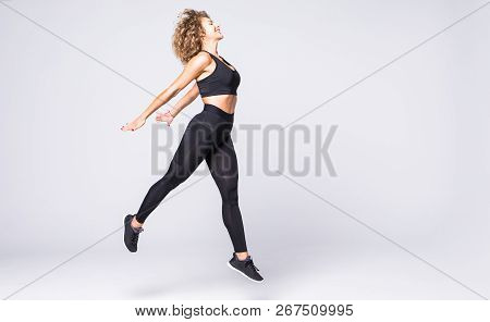 Side View Of A Sporty Young Fitness Woman Jumping Isolated On White Background