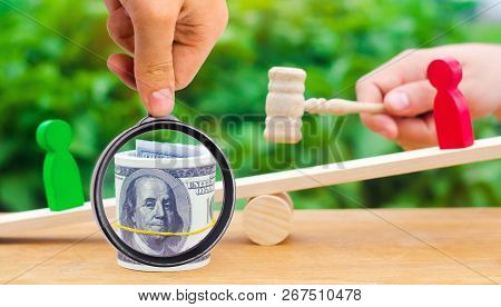 Wooden Figures Of People On Scales And Dollars Between Them. A Dispute Between Two Businessmen. Tria