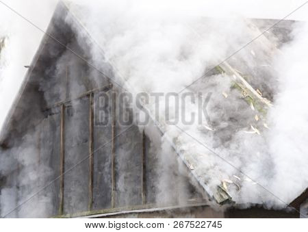 White Smoke Comes From The Burning Roof Of The House
