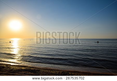 Sea Sunset. People Bathe In The Evening At Sunset In The Sea