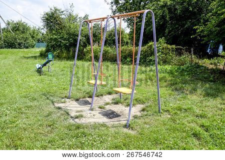 A Childrens Playground. Swing, Carousel And Slide