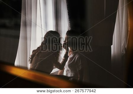 Makeup Artist Doing Brows And Applying Eyeshadow On Bride Face Close-up. Stylish Bride Getting Her M