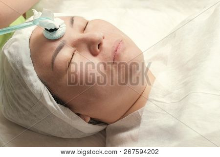 Darsonvalization. Close-up Of The Face Of A Muslim Woman On The Physiotherapy Facial Rejuvenation Pr