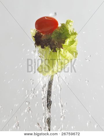 spalsh na salátu na bílém pozadí