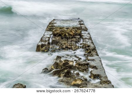 Old Pier In The Sea Drowned By Waves